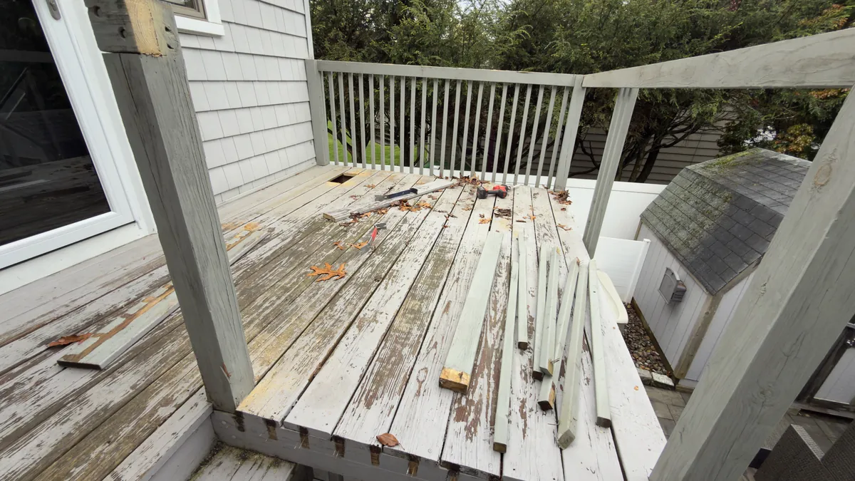 Before: weathered deck boards with loose planks and a peeling railing in Stratford, CT