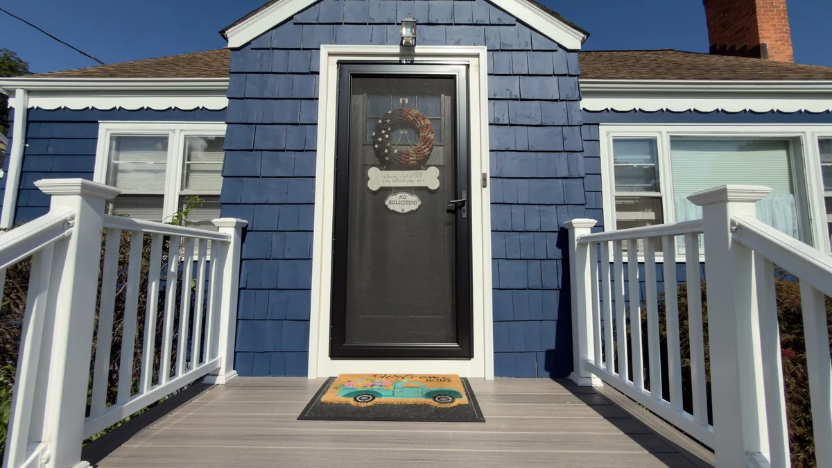 New black entry door with a full-view storm door at a navy blue house, with composite steps and white railings in Stratford, CT