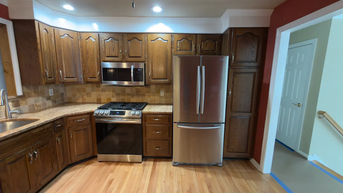 Before: dark oak cabinets, a laminate counter and the old refrigerator wall in Stratford, CT